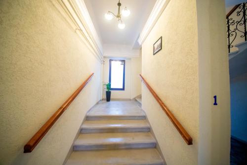 a hallway with stairs in a building with a window at H&H Luxury Apartments in Arad