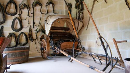 a horse drawn carriage hanging on a wall at Masseria Incantalupi in San Vito dei Normanni