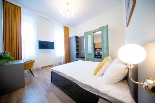 a bedroom with a bed and a lamp in it at H&H Luxury Apartments in Arad