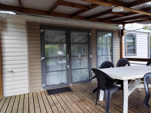 un patio avec une table et des chaises sur une terrasse dans l'établissement Camping la Vallée, à La Tour-dʼAuvergne