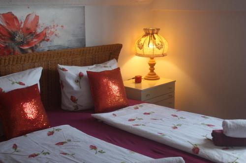 a bedroom with two beds and a lamp on a night stand at Harzspaß in Braunlage