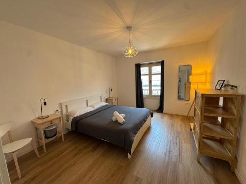a bedroom with a bed with a teddy bear on it at Suites Larios in Málaga