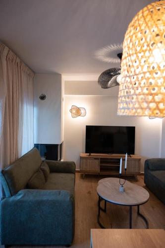 a living room with a couch and a flat screen tv at KLA SUITES by PROJECT 86 IKE in Nikiana