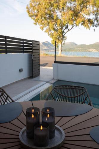 a table with three candles on a table with chairs at KLA SUITES by PROJECT 86 IKE in Nikiana