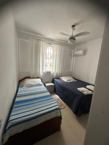 Un dormitorio con dos camas y un ventilador de techo. en Seaside apartment, AV Atlantic, en Balneário Camboriú