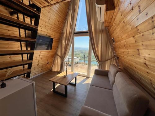 a living room with a couch and a large window at Doel House Zues in Shkodër