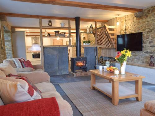 a living room with a couch and a fireplace at Cwm Hyfryd in Llanboidy