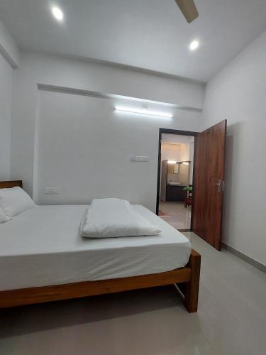 a bedroom with a large bed and a mirror at Achandy Arcade in Kakkadampoyil