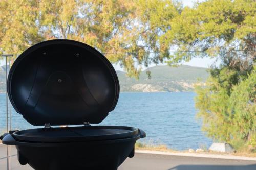 a black toilet with a black lid in front of a lake at KLA SUITES by PROJECT 86 IKE in Nikiana