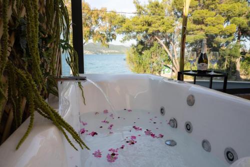 a bath tub with flowers in it with a view of the water at KLA SUITES by PROJECT 86 IKE in Nikiana