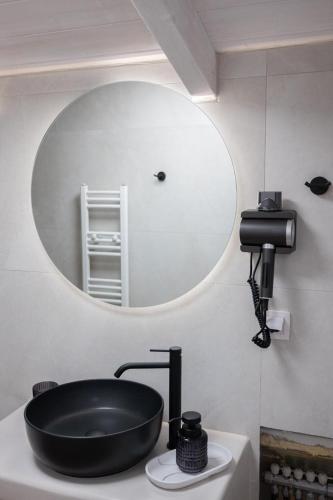 a bathroom with a black sink and a mirror at KLA SUITES by PROJECT 86 IKE in Nikiana