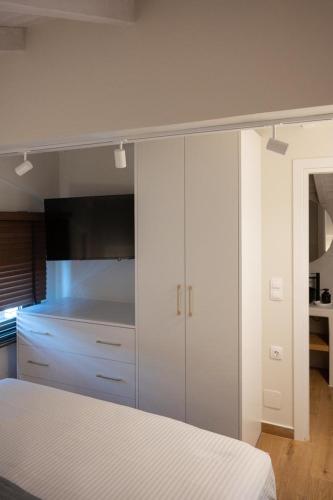 a bedroom with a bed and a white cabinet at KLA SUITES by PROJECT 86 IKE in Nikiana