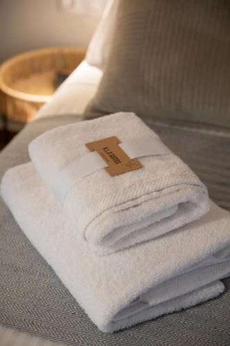 a pile of towels sitting on top of a bed at KLA SUITES by PROJECT 86 IKE in Nikiana