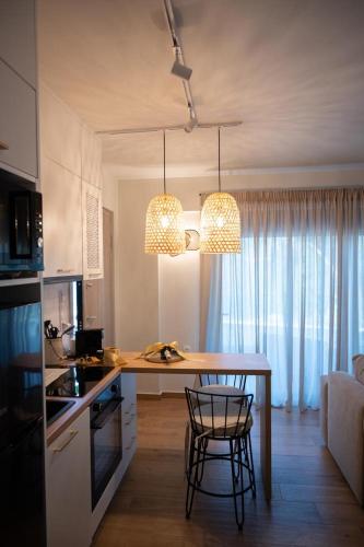 a kitchen with a table and chairs and two lights at KLA SUITES by PROJECT 86 IKE in Nikiana