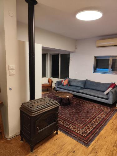 a living room with a blue couch and a wood stove at House in the countryside in H̱anniʼel