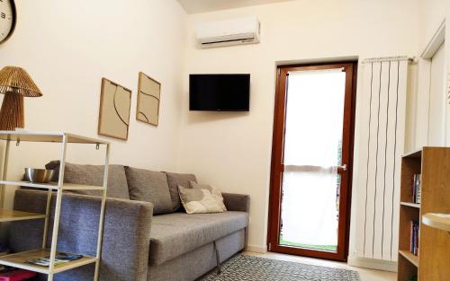 a living room with a couch and a tv at Holiday house in Rovetta