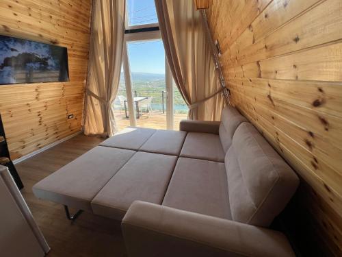 a living room with a couch and a large window at Doel House Zues in Shkodër