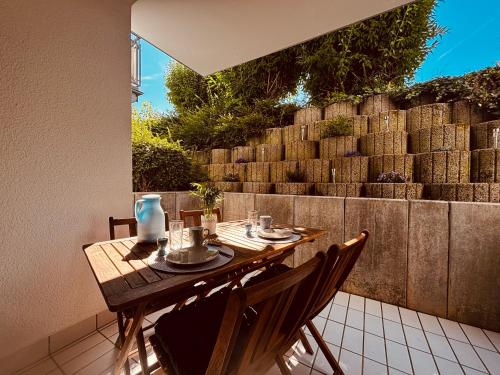 a table and chairs on a patio with a wall at Kleine Auszeit in Bad Kreuznach