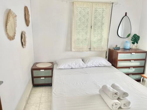 a bedroom with a bed with towels on it at The Beach house in Platanitis Rodopis