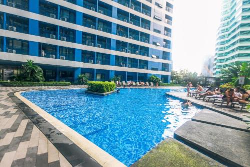 a large swimming pool in front of a building at Urban Luxe 1BR Makati central gym swim Park Fast Internet MB 3301 in Manila