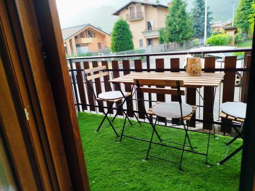 a wooden table and chairs on a balcony at Holiday house in Rovetta