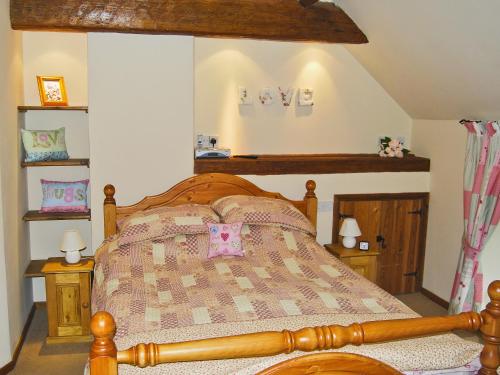 a bedroom with a bed with a love sign on the wall at Featherstone Cottage in Pickering