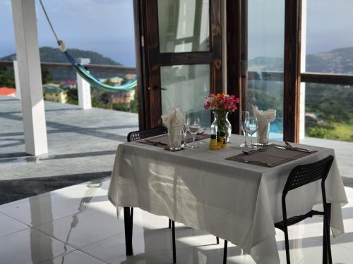 a white table with glasses and flowers on a balcony at WindBlow Villa in Belmont