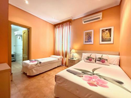 ein Schlafzimmer mit zwei Betten mit Blumen darauf in der Unterkunft Luz Madrid Rooms in Madrid