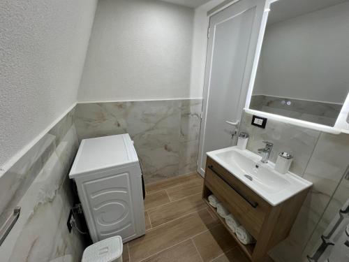 a white bathroom with a sink and a mirror at Doel House Zues in Shkodër