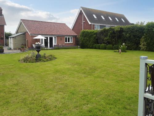 a house with a yard with a yard sidx sidx sidx sidx at Holly Lodge in Hemsby