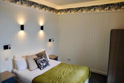 a bedroom with a bed with a green blanket at Lochnell Arms Hotel in Oban