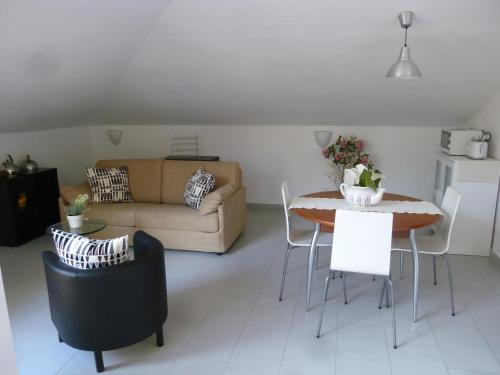 a living room with a couch and a table and chairs at Chà Apartment in Laigueglia