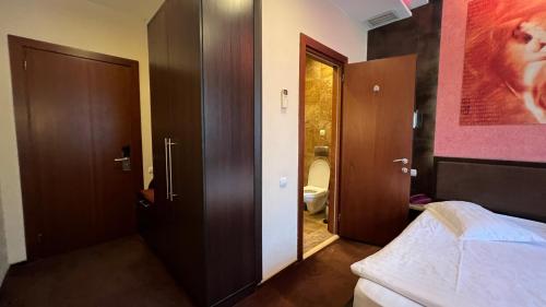 a room with a bedroom with a bed and a bathroom at JEPPESEN RESIDENCE in Almaty