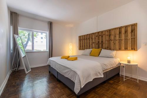 Un dormitorio con una cama grande con cabecero de madera. en Carcavelos Retreat, en Parede