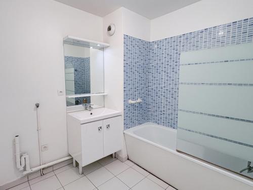 a white bathroom with a tub and a sink and a bath tub at Studio proche de Disneyland Paris in Bussy-Saint-Georges