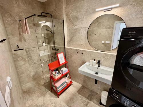 um banheiro com chuveiro, pia e espelho em Meridian Bratislava - Stylish Brand New Apartment in the City Center & Free Garage Parking em Bratislava