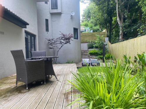 a patio with chairs and a table in a yard at Parkside Lodge - Luxury Coastal Hideaway for Two in Brixham