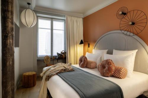 a bedroom with a large bed with pillows and a window at LE CLARK HOTEL in Paris