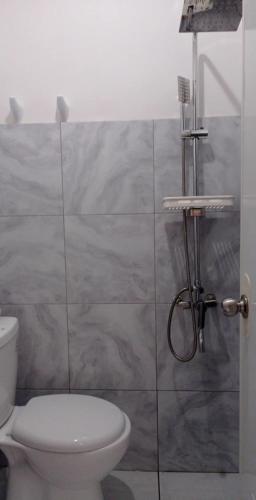 a bathroom with a toilet and a shower at AMS Hostel Butuan City in Butuan