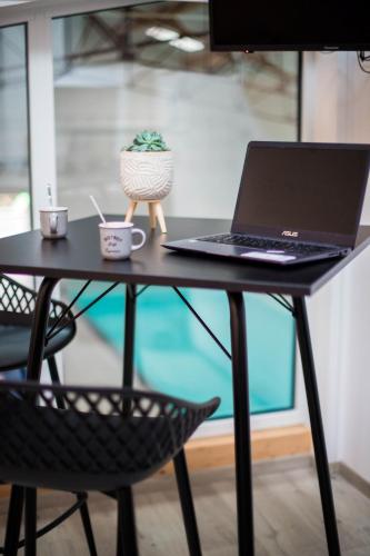 un ordinateur portable assis sur une table avec une chaise dans l'établissement L'Atelier Dollonnais, à Dollon