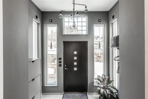 a hallway with a black door and windows at Island Villa in Sundsvall Alnö in Alnön