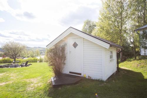 a small white shed in a field of grass at Island Villa in Sundsvall Alnö in Alnön