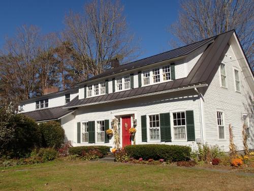 a white house with a red door at Artful Lodging & Retreats in Montpelier