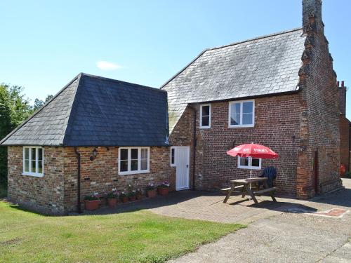 a brick house with a red umbrella in front of it at Hawthorne Cottage - Py8 in Preston