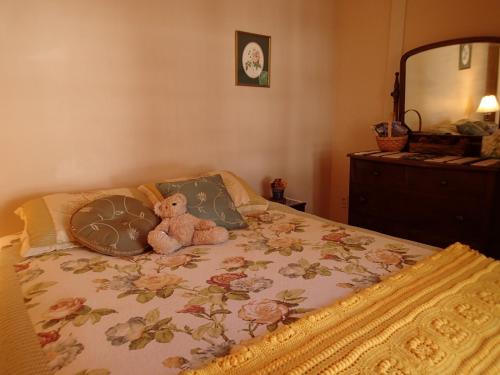 a teddy bear sitting on top of a bed at Artful Lodging & Retreats in Montpelier