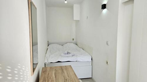 a small white room with a bed and a mirror at Apartment Andrevski in Ohrid