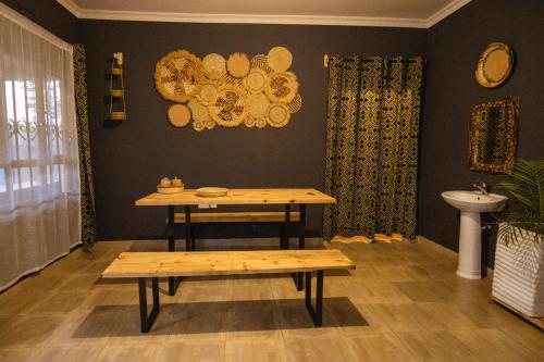 Una mesa y un banco en una habitación con lavabo. en Simba homes, en Arusha