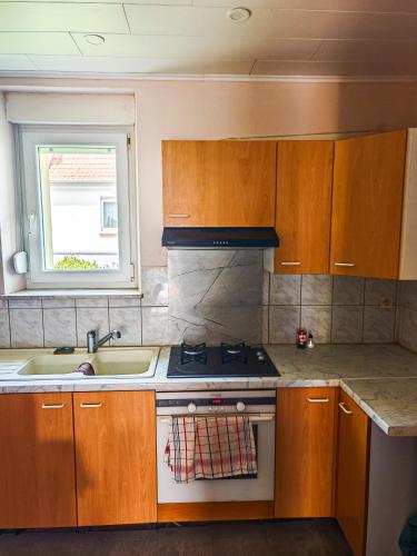 Il comprend une cuisine équipée d'une cuisinière et d'un évier. dans l'établissement Appartement agréable et atypique, rénové, wifi, terrasse, jardin, à Schleithal