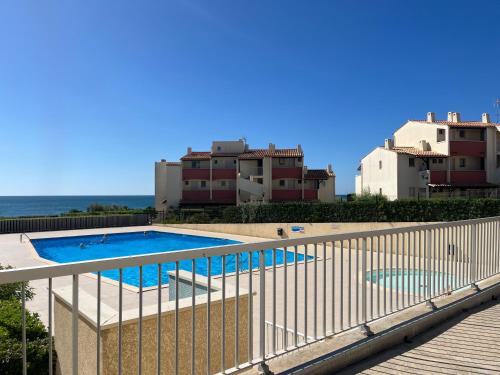 - un balcon avec vue sur la piscine et les bâtiments dans l'établissement INDES GALANTES Tres joli T2 vue mer piscine Cap d'Agde, au Cap d'Agde