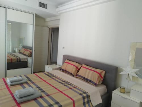a bedroom with a large bed and a mirror at Skopje Sky Apartments & Floor 33th 28th & 25th & 19th & 13th 12th With Pool & Spa & Fitness & Parking Included in Price in Skopje